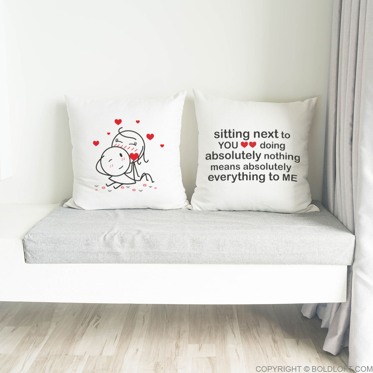 BoldLoft You Mean Everything to Me Couple Pillowcases in White- Two 26x26 euro pillows with romantic designs and text on a bench against a white wall. Cute his and her bedroom decors for boyfriend girlfriend husband and wife.